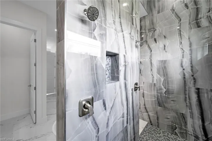 Bathroom with a tile shower and tile flooring