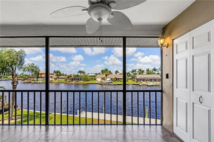 Unfurnished sunroom featuring a water view, a residential view, and tile patterned floors