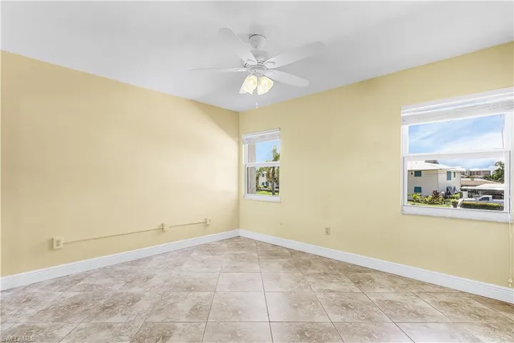 2nd Bedroom with ceiling fan and light tile patterned floors
