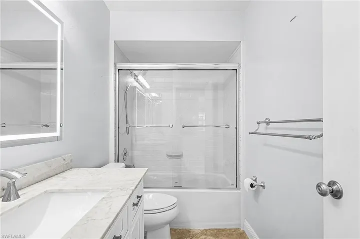 2nd Bathroom featuring enclosed tub / shower combo, vanity, and light tile patterned floors