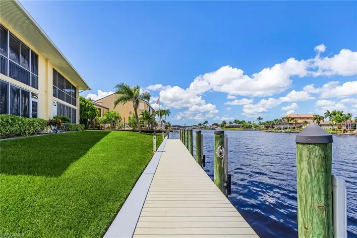 Dock area with a yard and a water view