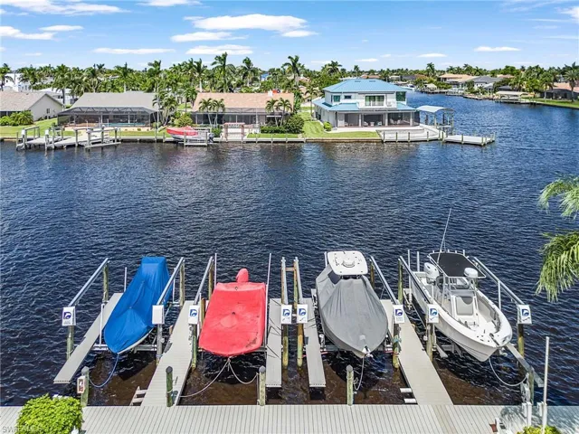 Dock with boat lift, a water view, and a residential view