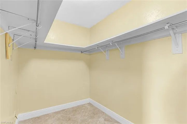 Primary Walk in closet with light tile patterned floors