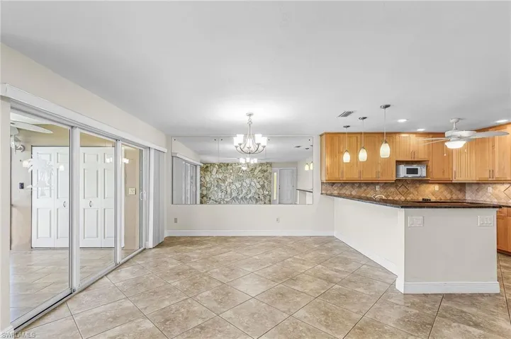 Kitchen featuring ceiling fan, tasteful backsplash, a peninsula, brown cabinetry, and recessed lighting