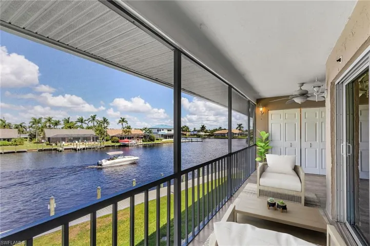 Balcony featuring a water view, a residential view, and a ceiling fan- Virtually staged
