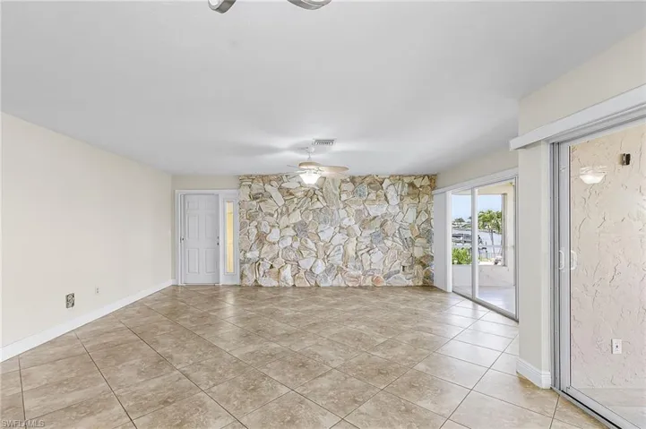 Unfurnished room with ceiling fan and light tile patterned flooring