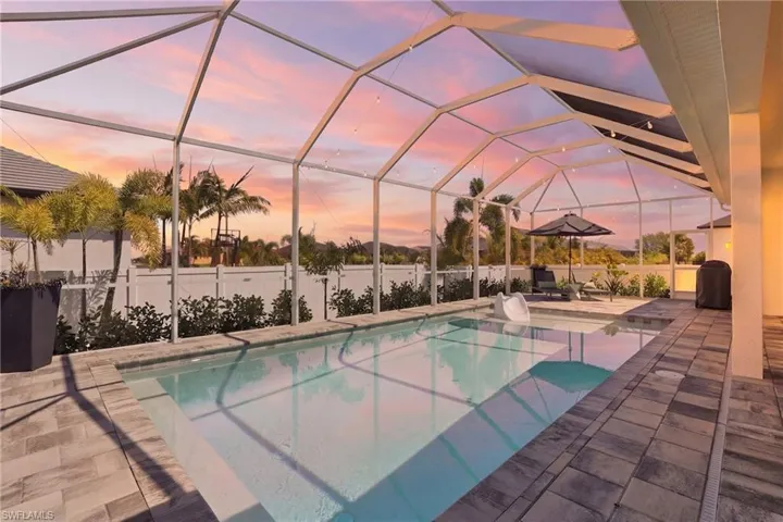 Saltwater pool with screen enclosure at twilight