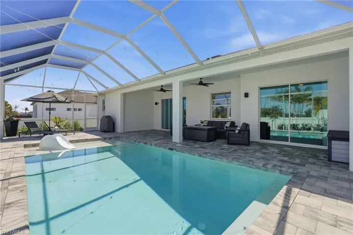 Swimming pool with outdoor lounge area, a sunroom, a lanai, and a patio area