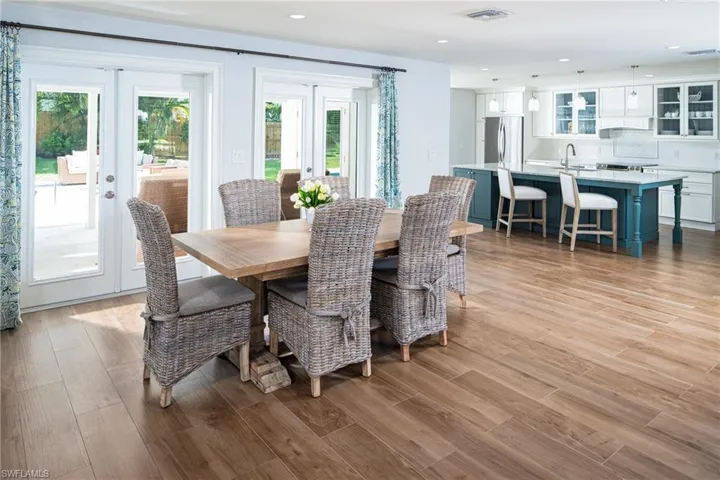 Dining room with french doors, light wood-type flooring, and recessed lighting