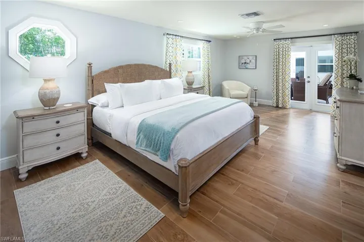 Bedroom with multiple windows, access to exterior, and wood finished floors