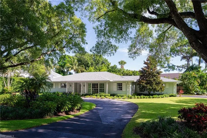 Single story home with a front yard and curved driveway