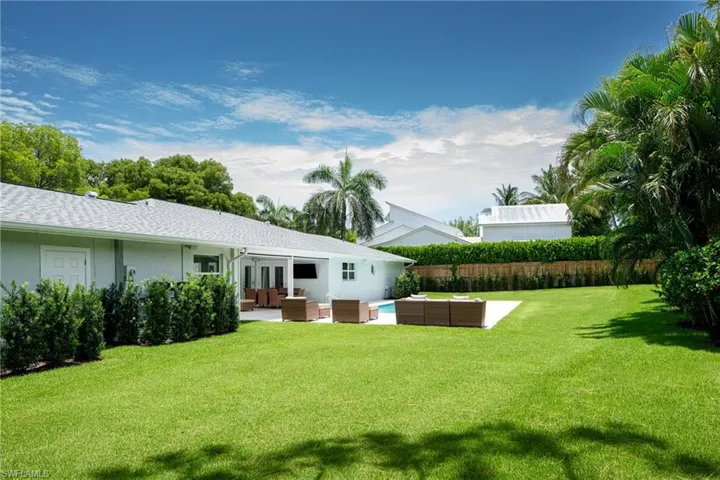 View of green lawn with an outdoor hangout area and a patio