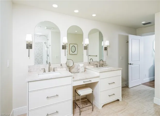 Full bathroom with double vanity, a shower stall, and recessed lighting