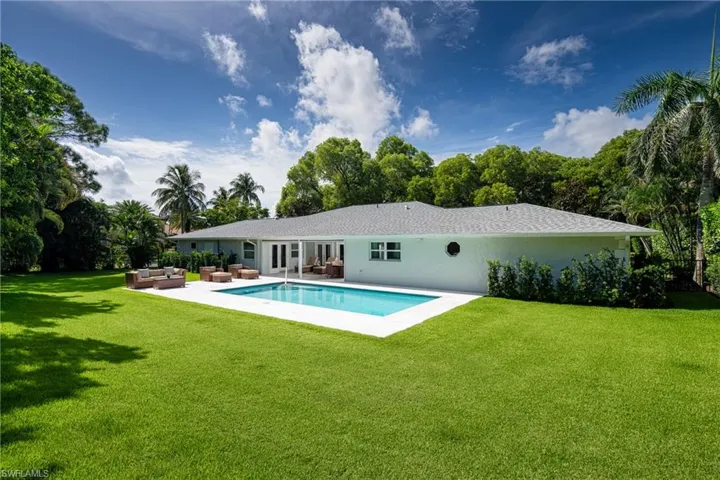 Outdoor pool featuring an outdoor living space, a yard, a patio area, french doors, and view of wooded area