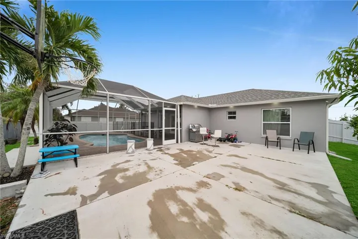 Rear view of property featuring a patio area, a fenced in pool, and a lanai