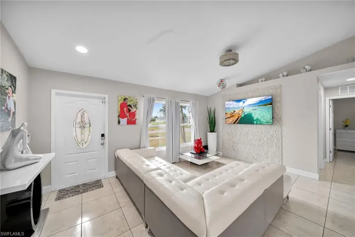 Tiled living room featuring lofted ceiling