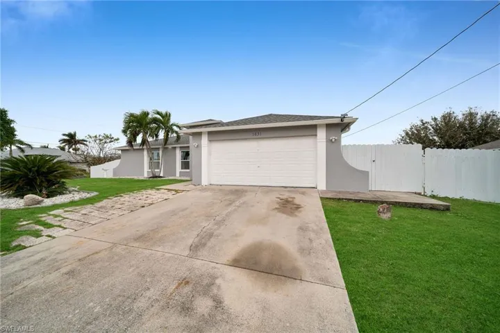 View of front facade with a garage and a front lawn