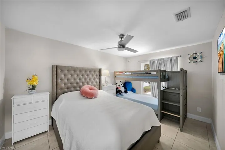 Bedroom featuring light tile patterned floors and ceiling fan