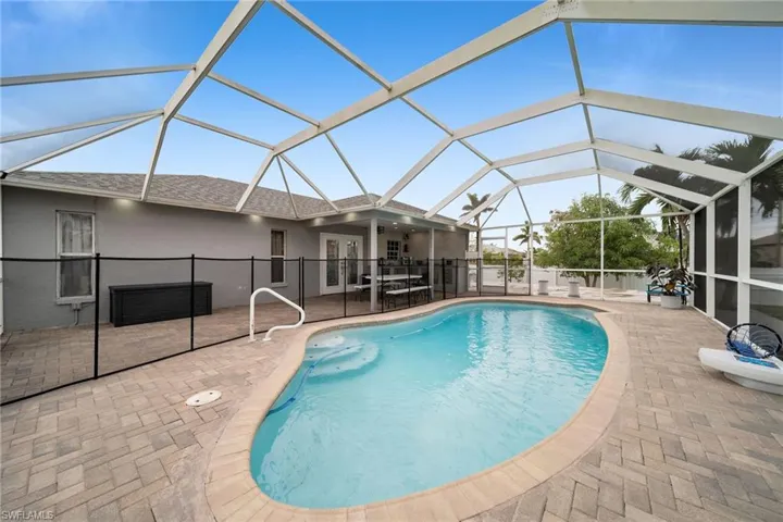 View of swimming pool with a patio area and glass enclosure