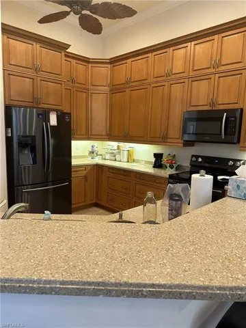 Kitchen featuring ceiling fan, sink, ornamental molding, and appliances with stainless steel finishes