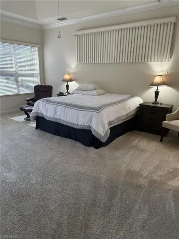 Carpeted bedroom featuring crown molding