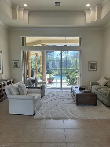 Living room featuring tile patterned flooring and crown molding