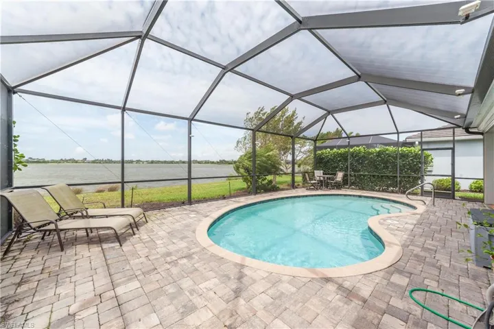 Pool with a water view, screen enclosure, and a large patio area