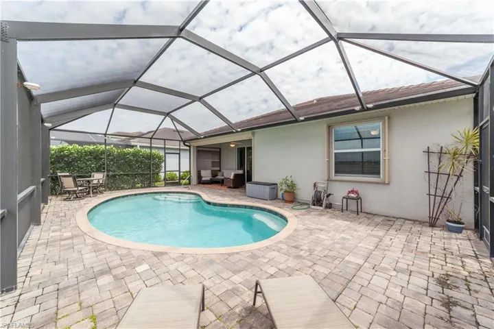 Heated salt water Pool featuring a lanai, a patio, and an outdoor living space