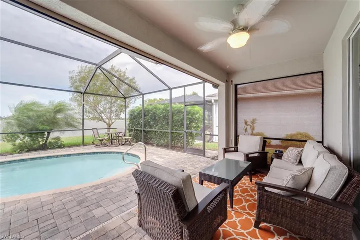 Outdoor pool with glass enclosure, an outdoor living space, a ceiling fan, and a patio
