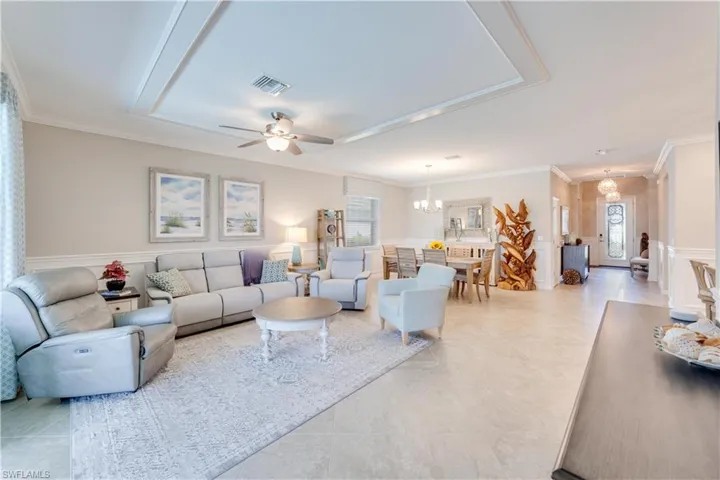 Truly open concept. Living room with a healthy amount of sunlight, crown molding, and ceiling fan.