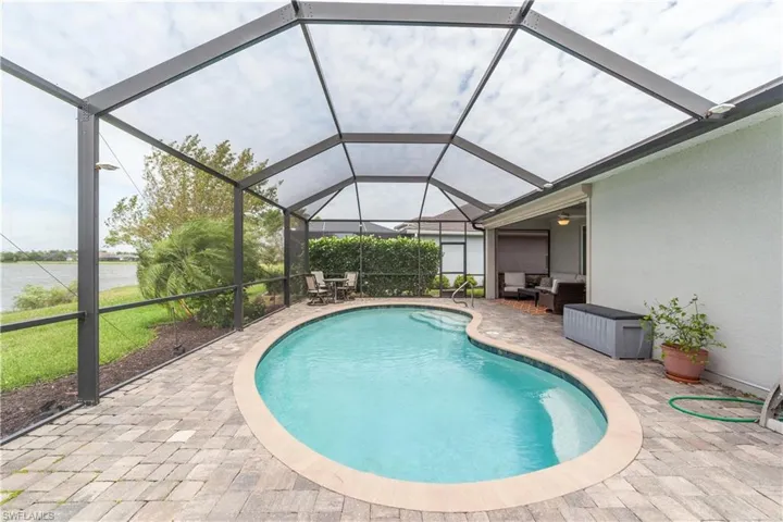 Outdoor pool featuring a lanai, outdoor lounge area, and a patio