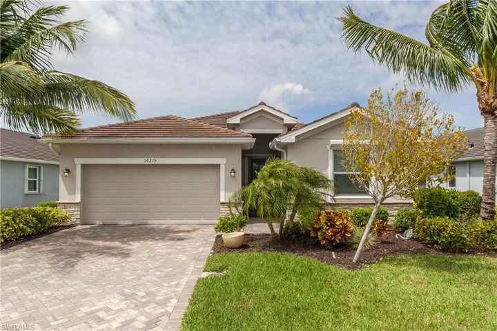 Single story spacious home with an attached garage, stone siding, decorative driveway, and stucco siding