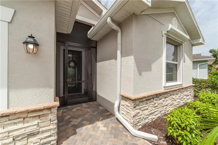 Entrance to property featuring stone siding and stucco siding