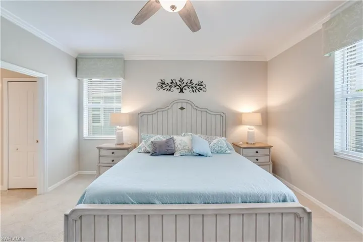 Primary Bedroom featuring crown molding, ceiling fan, baseboards, and light colored carpet