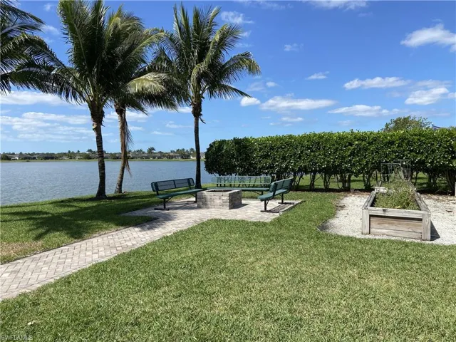 View of home's community with a water view, a patio area, and a fire pit