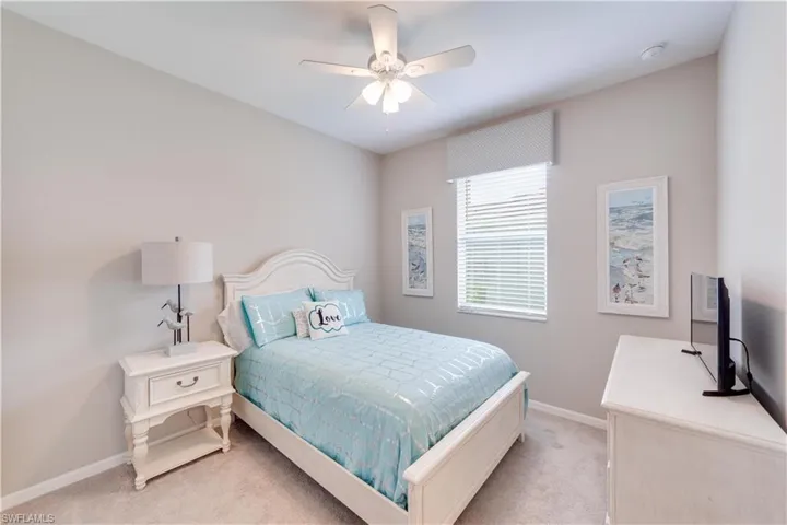 Second Bedroom featuring light carpet, a ceiling fan, and baseboards