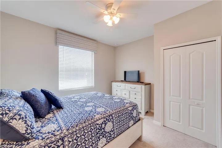 Third Bedroom with a ceiling fan, a closet, light colored carpet, and baseboards