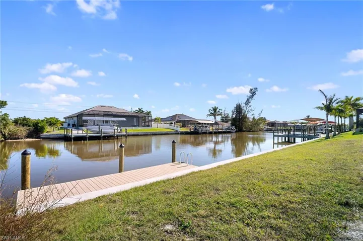Dock area with a lawn, a water view, and a residential view