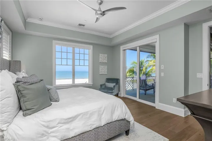 Bedroom with dark wood finished floors, ceiling fan, access to outside, and ornamental molding