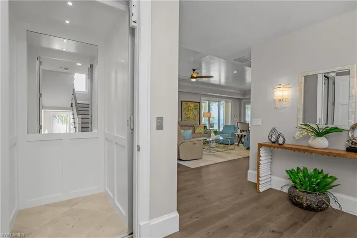 Corridor with elevator, light wood finished floors, and recessed lighting