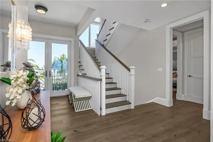 Stairway featuring french doors, wood finished floors, and recessed lighting
