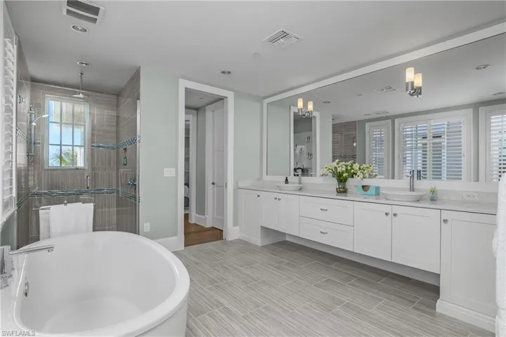 Bathroom with a shower stall, a freestanding tub, double vanity, and wood tiled floors