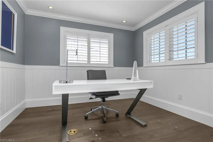 Office area with dark wood-type flooring, a wainscoted wall, recessed lighting, and ornamental molding