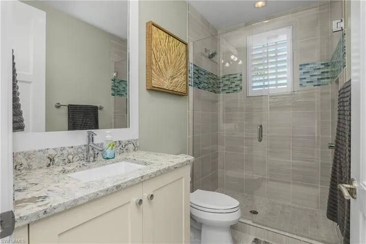 Bathroom featuring vanity and a shower stall