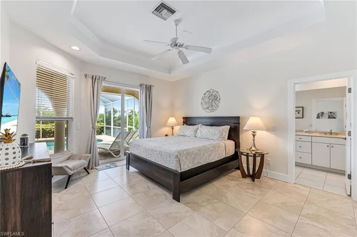 Bedroom featuring access to outside, a tray ceiling, ornamental molding, ceiling fan, and recessed lighting