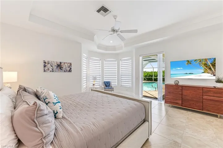 Bedroom featuring crown molding, recessed lighting, light marble finish flooring, ensuite bath, and a ceiling fan