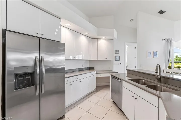 Dining space with a high ceiling, light tile patterned flooring, and ceiling fan