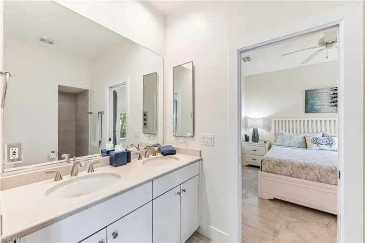 Ensuite bathroom featuring tiled shower, tile patterned flooring, and ceiling fan