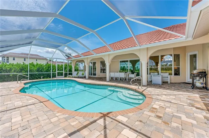 Outdoor pool with a patio area and glass enclosure