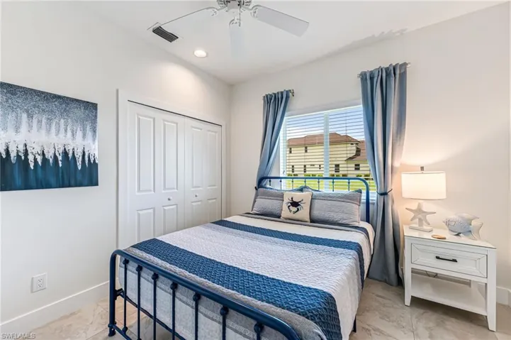 Bedroom featuring multiple windows, a ceiling fan, and a closet